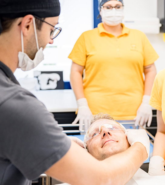 Medizinisches Team bereitet Patienten auf kosmetische Behandlung vor.